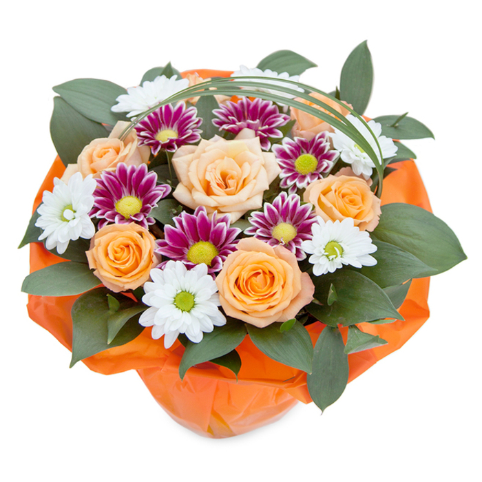 Emanating charm and artistry, this lush bouquet reflects the unique blend of tradition and creativity synonymous with Tufnell Park's diverse floral scene. Seen from a gently elevated viewpoint, the bouquet's focal roses-tightly furled and unfolding-offer a palette of soft peach blending into luminous orange, their velvet petals layered with care to inspire feelings of warmth and gracious celebration. The roses are interwoven with two distinct chrysanthemum types: daisy-like whites centering on chartreuse green discs, and finer-petaled chrysanthemums flashing intense magenta and purple, their centers glowing a vivid yellow-green. Generous, deep green foliage-broad-leaved and robust-forms an embracing backdrop, its textures reflective of well-tended local gardens. Above, a delicate loop of vivid green bear grass arches-a clever modern accent that evokes the curves found in the nearby Reservoir grounds. The base is thoughtfully wrapped in crumpled, sheer orange tissue that complements the arrangement's fiery hues and gives a cheerful finish, much like the shopfronts lining Brecknock Road. Designed by a florist with local expertise, this bouquet radiates not only the beauty of fresh blooms but also an invitation to celebrate life's special moments-from birthdays to housewarmings-anywhere in Tufnell Park. Each detail, from the interplay of soft and bright hues to the soft rustle of petals and paper, highlights the sophisticated balance between natural abundance and artistic arrangement that local residents value.